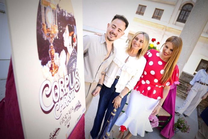 La alcaldesa de Granada, Marifrán Carazo, junto al cartel del Corpus 2026 y rodeada del autor del mismo, José Manuel Valverde, y la pregonera de esta edición, la periodista Mónica Martínez Leyva.