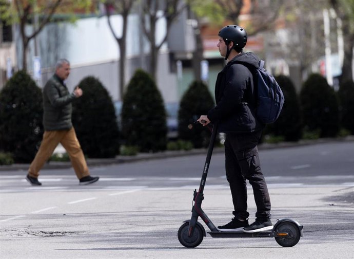 Archivo - Un hombre montado en un patinete eléctrico, a 5 de abril de 2024, en Madrid (España).