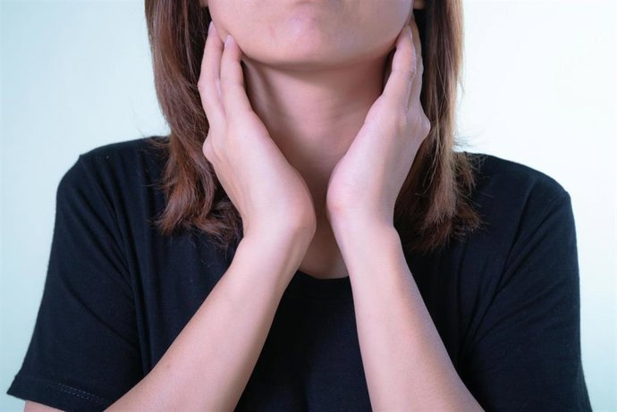 Mujer tocándose la garganta. Archivo.