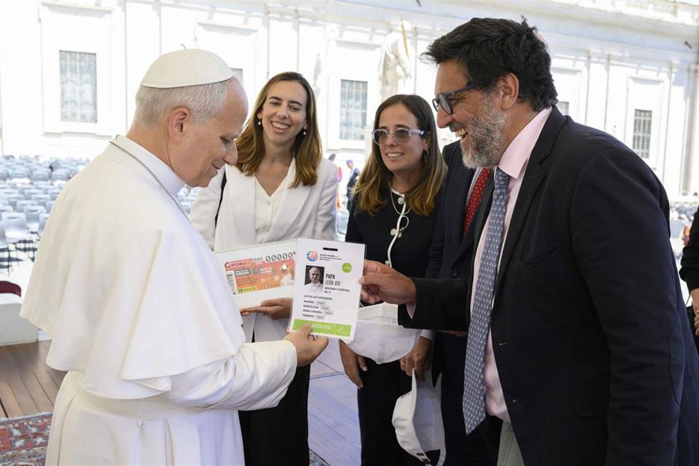 El coordinador de comunicación de la visita del Papa a España, Rafael Rubio, entrega su acreditación al Papa.