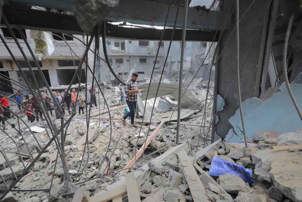 Palestinos entre viviendas destruidas por bombardeos del Ejército de Israel contra el campamento de refugiados de Al Maghazi, en el centro de la Franja de Gaza (archivo)