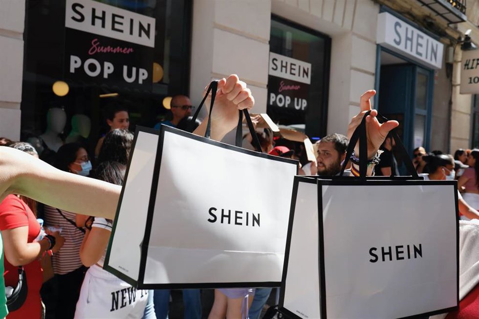Archivo - Dos personas sujetan dos bolsas de Shein después de entrar a la primera tienda física de SHEIN en Madrid, a 2 de junio de 2022, en Madrid (España). 