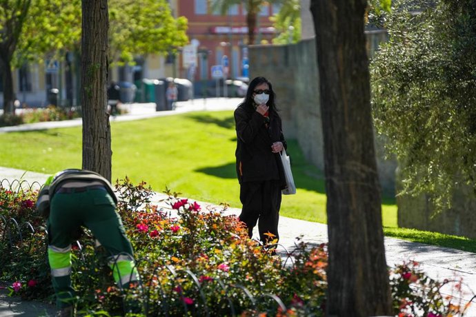 Archivo - Mujer con mascarilla paseando por un parque