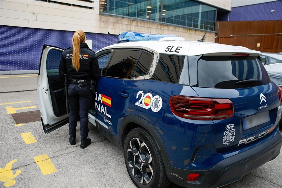 Archivo - Agente entrando a un vehículo de la Policía Nacional en Barcelona