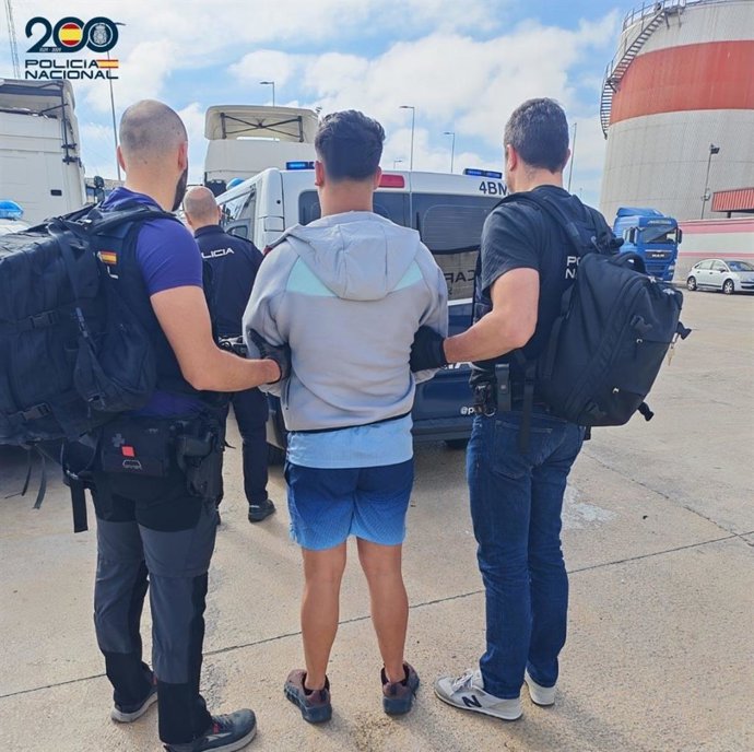 Dos policías nacionales acompañan al detenido por numerosos delitos para prodecer a su deportación a Marruecos.