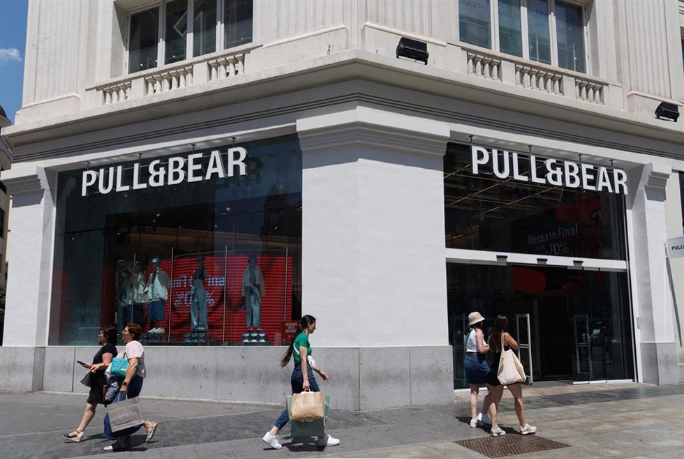 Archivo - Varias personas pasan por delante de una tienda de Pull&Bear