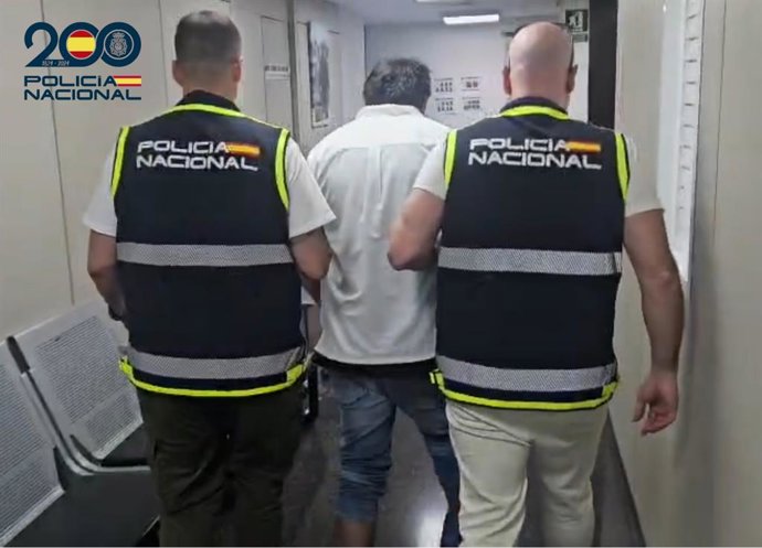 El detenido, escoltado por dos agentes de la Policía Nacional.