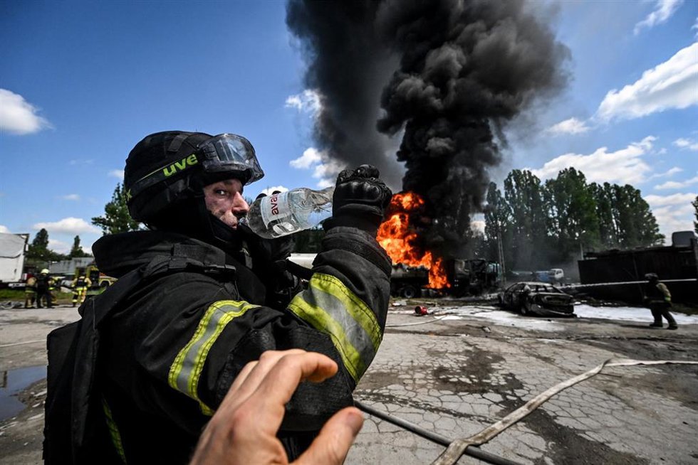 Archivo - Un bombero bebe agua mientras los equipos de rescate apagan los camiones cisterna en llamas que una empresa privada utilizaba para abastecer a cadenas de gasolineras, tras un ataque con drones rusos en Zaporiya, Ucrania