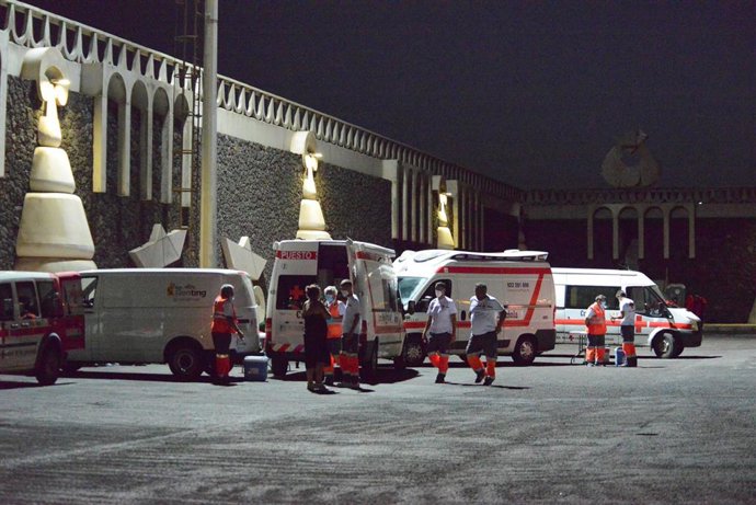 Archivo - Vehículos de Cruz Roja, atienden a varios migrantes a su llegada al muelle de La Restinga tras ser rescatados de una patera
