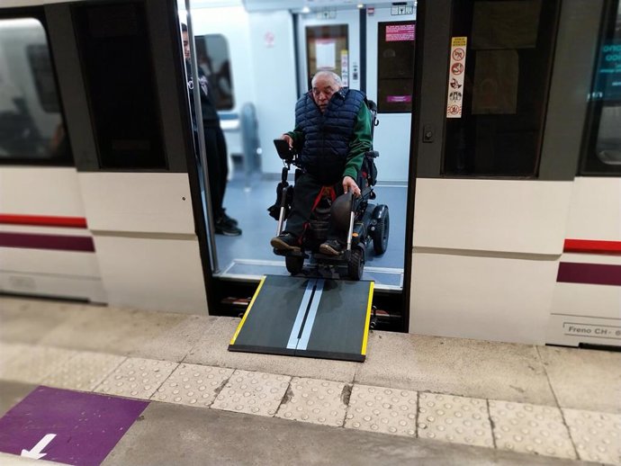 Un usuario de Renfe Cercanías utiliza una rampa para descender del tren.
