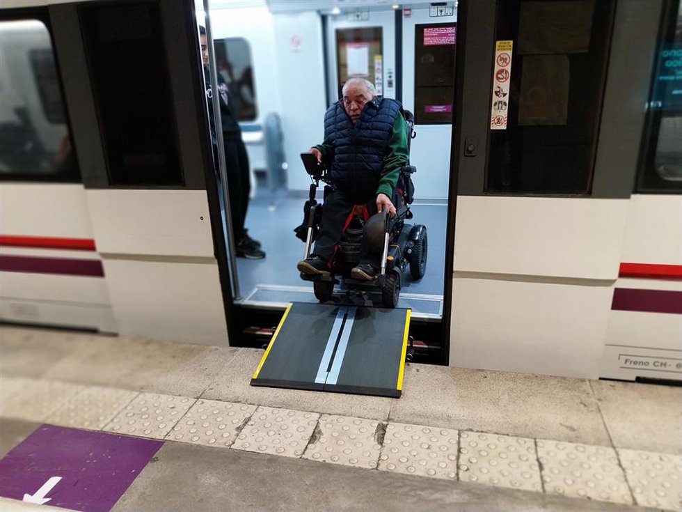 Un usuario de Renfe Cercanías utiliza una rampa para descender del tren.