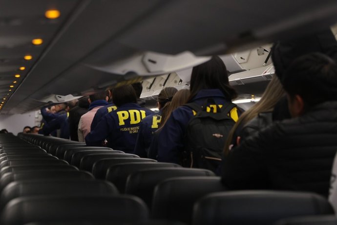 Agentes de la PDI chilena escoltan a migrantes en un vuelo de deportación