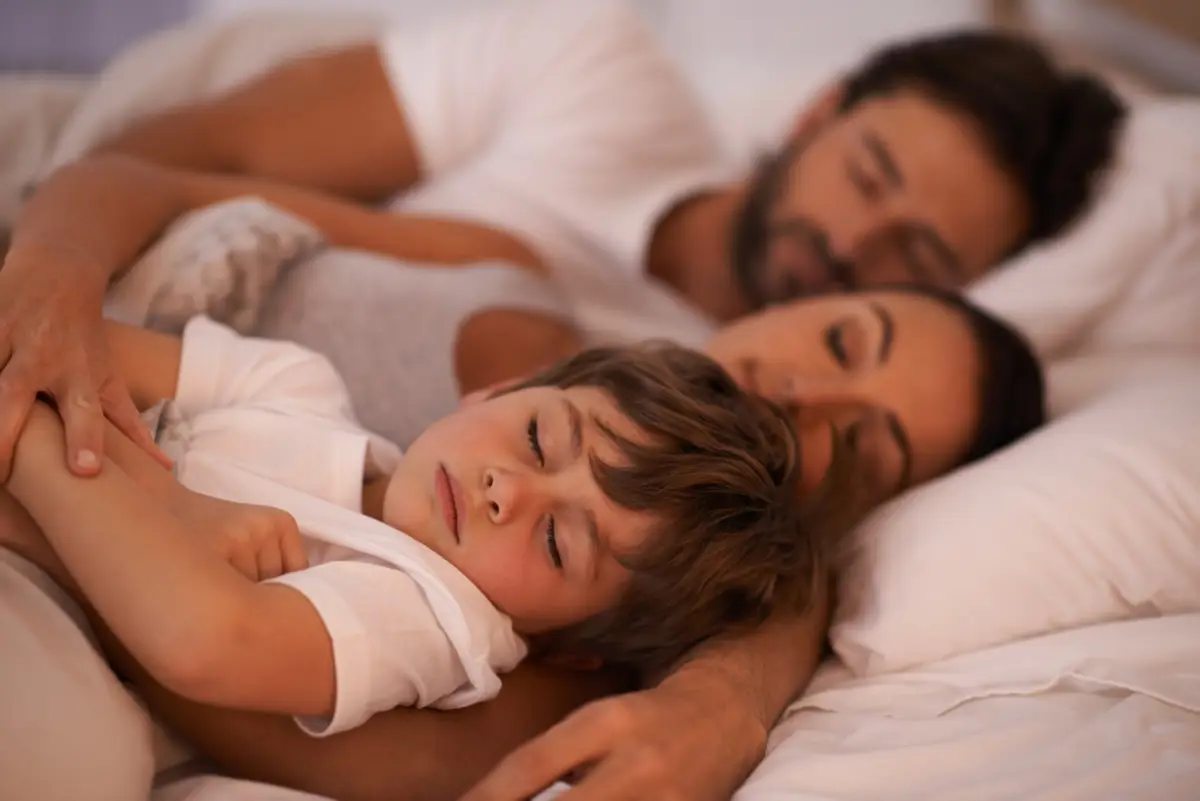 Niño durmiendo con sus padres