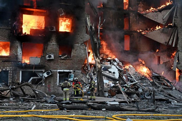 Bomberos intentan sofocar un fuego provocado por un proyectil ruso, en Kiev.