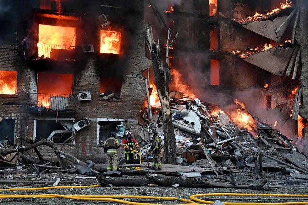 Bomberos intentan sofocar un fuego provocado por un proyectil ruso, en Kiev.