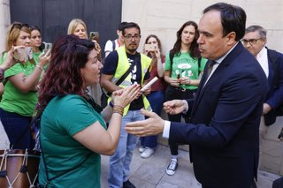 Imagen de archivo del 'president' de la Generalitat, Juanfran Pérez Llorca (d), hablando con representantes de docentes a la salida de una sesión de control en Les Corts Valencianes