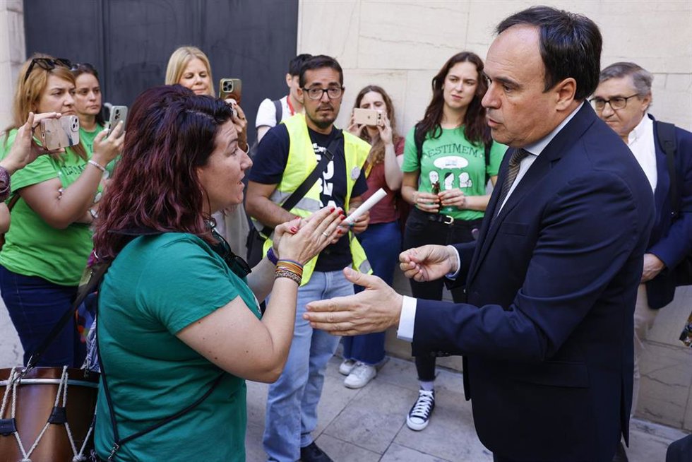 Imagen de archivo del 'president' de la Generalitat, Juanfran Pérez Llorca (d), hablando con representantes de docentes a la salida de una sesión de control en Les Corts Valencianes