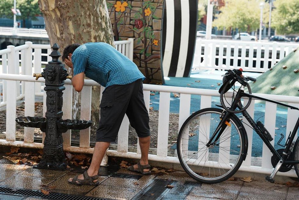 Archivo - Un hombre se moja la cara con el agua de una fuente.
