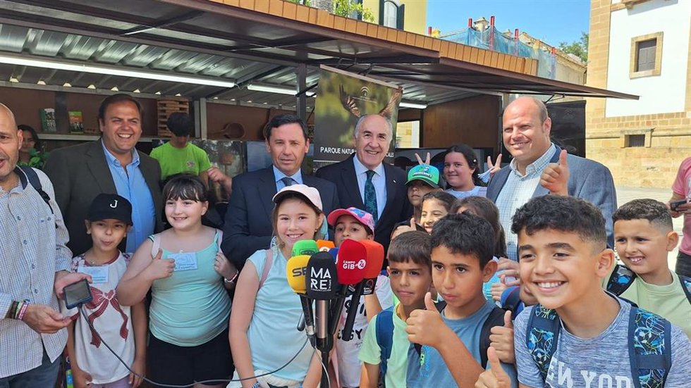 Oscar Curtido, Javier Ros y el alcalde de Algeciras con niños en la Feria de los Parques Naturales en la Plaza Alta.
