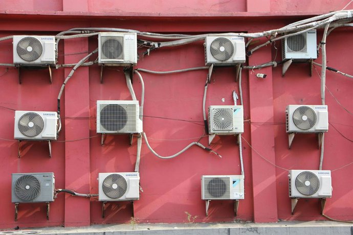 Aires acondicionados en una pared roja