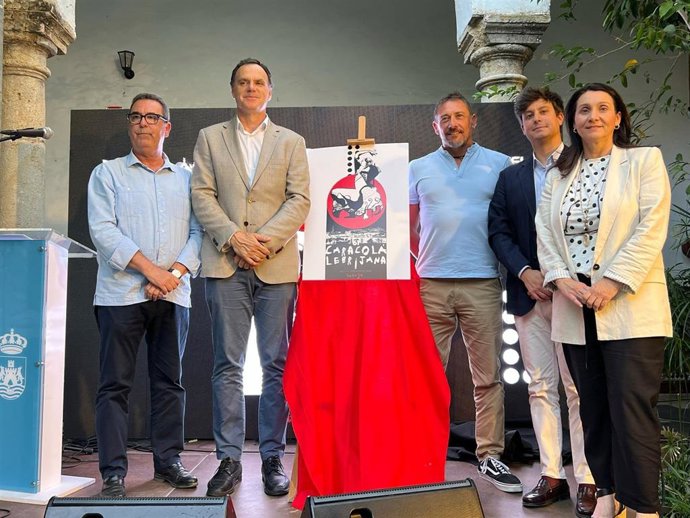 El alcalde de Lebrija (2i) y el diputado de Cultura (2d), junto al cartel de la Caracolá Lebrijana, que encara su edición número 61, en un acto celebrado en el municipio para entregar a la Diputación el 'Caracol de Oro'