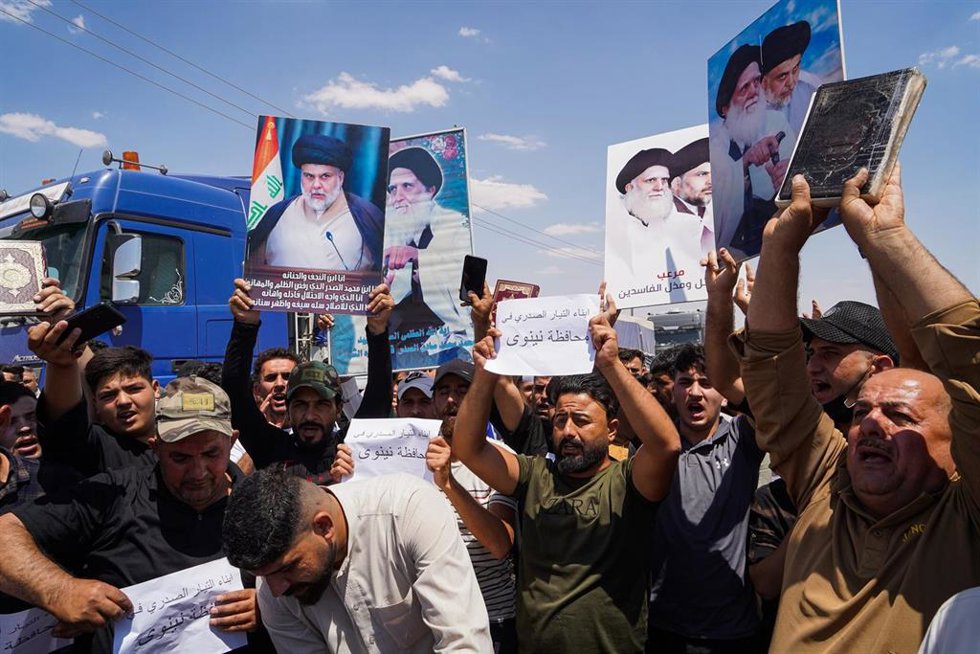 Archivo - Un partidario del clérigo chií iraquí Moqtada al-Sadr sostiene un Corán durante la manifestación celebrada cerca del distrito de al-Hamdaniya en Irak en 2023.