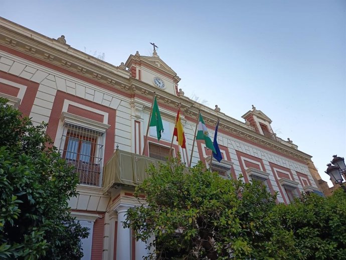 Fachada principal de la Casa de la Provincia, con las banderas oficiales y una colgadura con el clásico color verde y el escudo de la Diputación bordado en el centro
