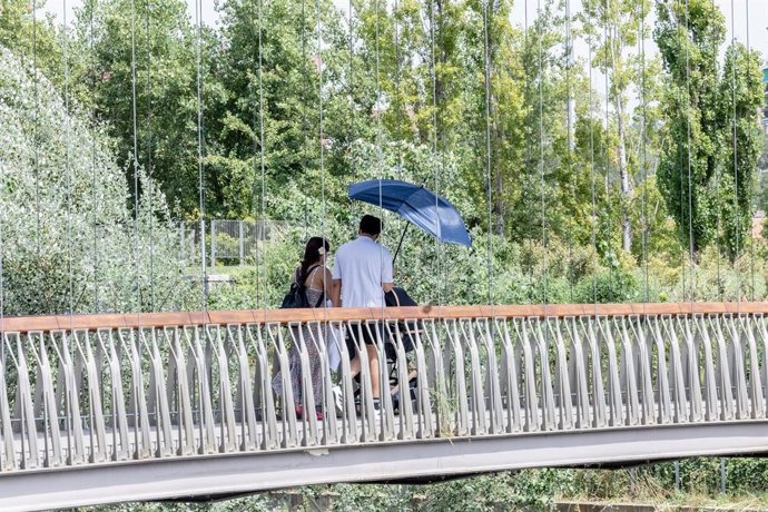 Archivo - Dos personas se protegen del sol con una sombrilla, a 12 de agosto en Madrid (España). La Agencia Estatal de Meteorología (AEMET) ha extendido el aviso por ola de calor "probablemente hasta el lunes 18 de agosto". Dado que comenzó el pasado día 