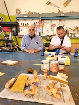 Fernando (a la izquierda) y un compañero en el taller del CTA, junto a las piezas del árbol que regalarán al Papa.