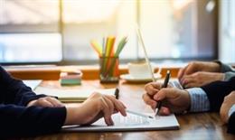 Archivo - Imagen de recurso de dos personas firmando unos documentos.