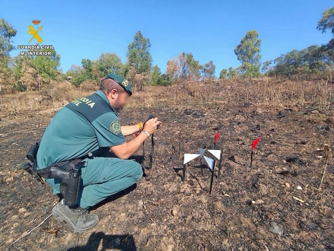 Un agente de la Guardia Civil investiga el oriden de un incendio forestal.