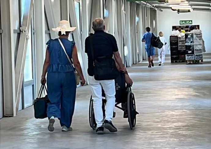 Dos personas empujan una silla de ruedas en el aeropuerto de Palma.