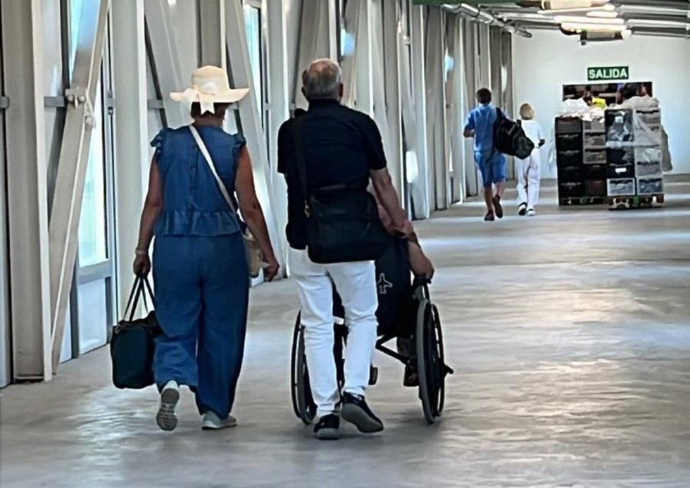 Dos personas empujan una silla de ruedas en el aeropuerto de Palma.