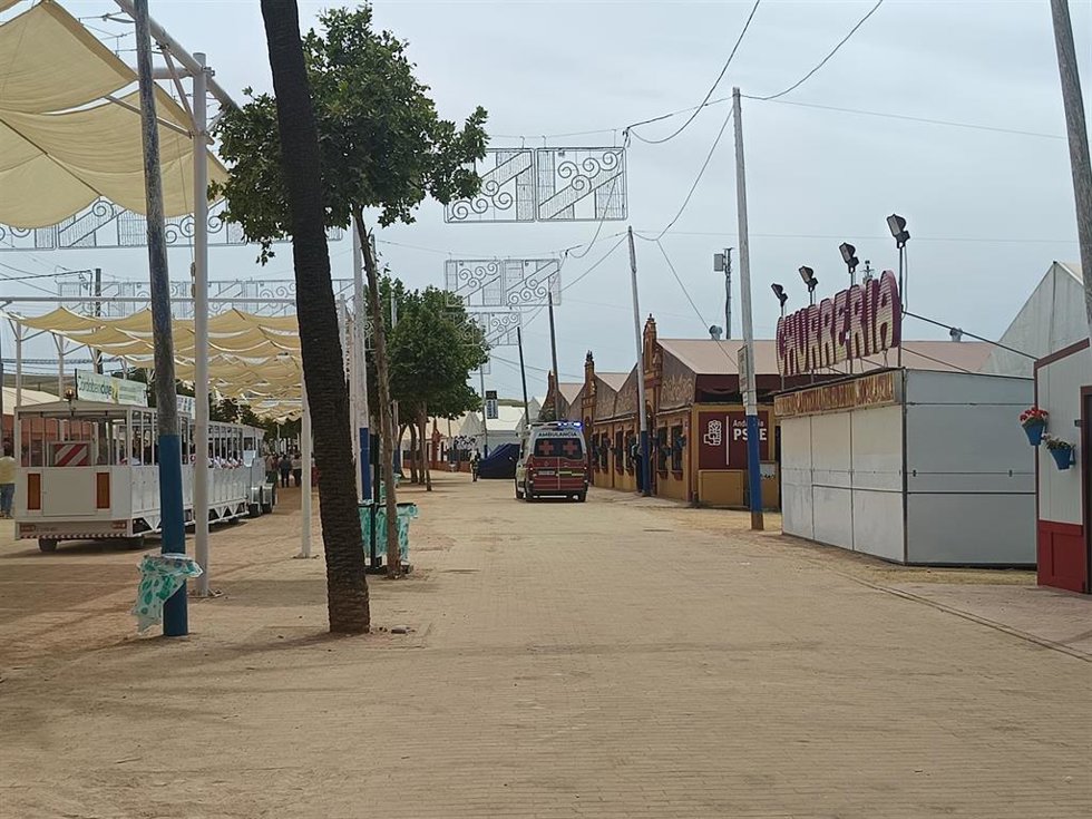 Una ambulancia (fondo, dcha.) presta un servicio en el recinto ferial de El Arenal durante la Feria de Nuestra Señora de la Salud.