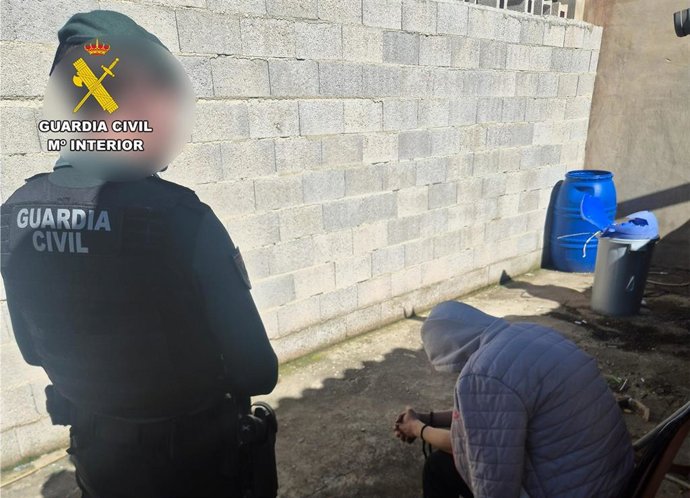 Un agente de la Guardia Civil junto a uno de los detenidos en la operación 'Battuto'