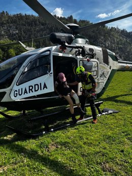 Un helicóptero de la Guardia Civil atiende a una persona en un rescate de montaña.