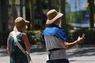 Turistas se protegen del calor en una imagen de archivo