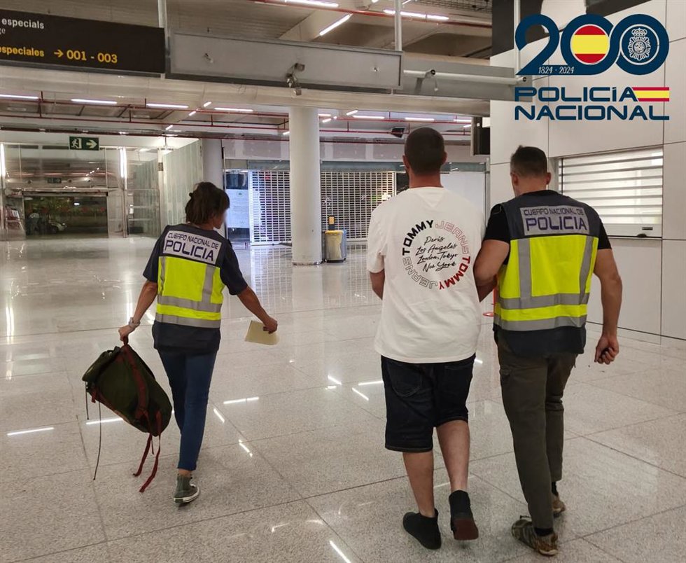 Agentes de la Policía Nacional acompañan al detenido por tratar de salir de Mallorca.