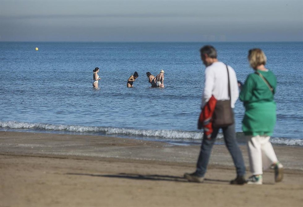 Archivo - Varias personas caminan por la playa de la Malvarrosa.