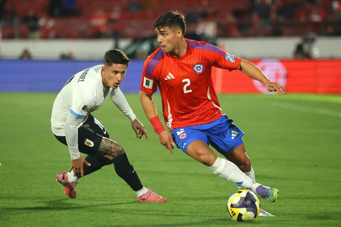 Futbol, Chile vs Uruguay. Eliminatorias al mundial de la Fifa 2026. El jugador de la seleccion chilena Fabian Hormazabal, derecha, disputa el balon con Brian Rodriguez de Uruguay durante un partido clasificatorio al mundial de 2026 realizado en el