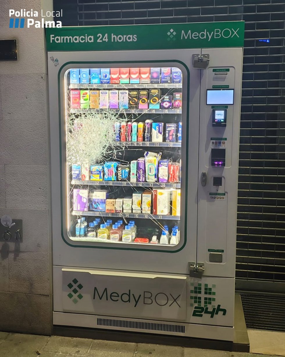 Máquina expendedora de una farmacia con el cristal roto.