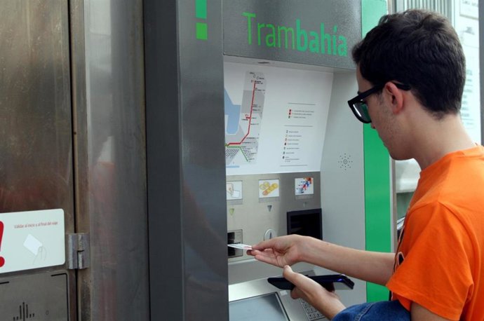Imagen de una persona sacando un billete del Trambahía.