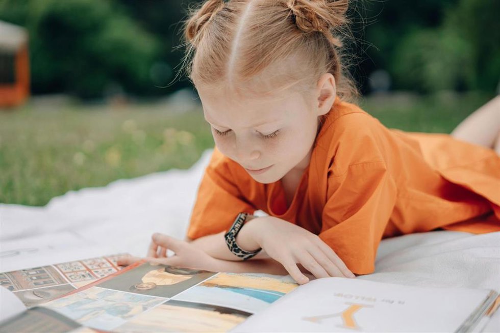 Una niña lee un libro.