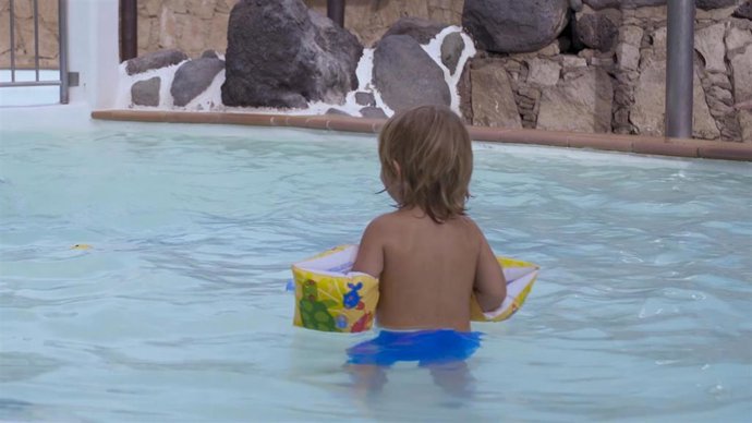 Un niño se baña en una piscina