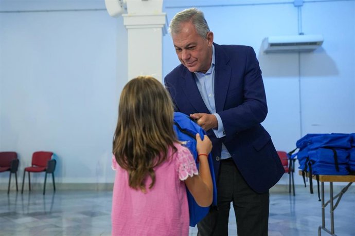 El alcalde entrega una mochila a una alumna dentro del programa municipal 'Equípate'
