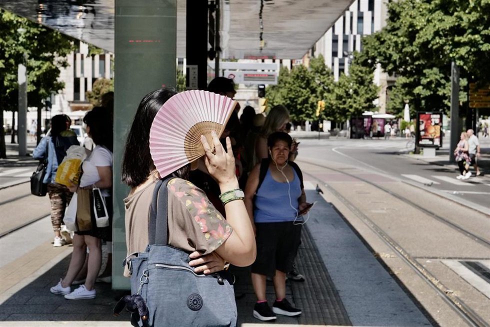 Archivo - Una mujer se tapa del sol con un abanico en la parada del tranvía del Paseo de La Independencia, a 10 de julio de 2023, en Zaragoza, Aragón (España). 