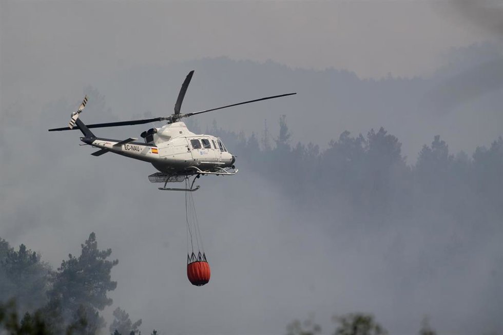 Archivo - Un helicóptero trabaja en las labores de extinción de un incendio. Foto de archivo.