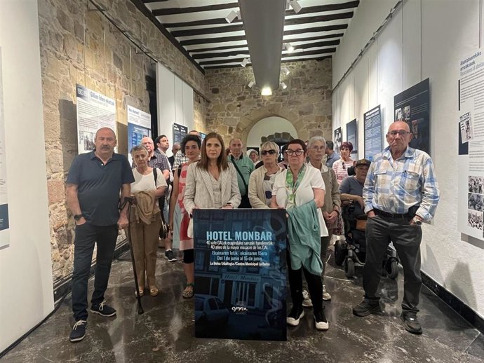 La consejera María Jesús San José, víctimas del GAL y familiares posan en la inauguración de la exposición
