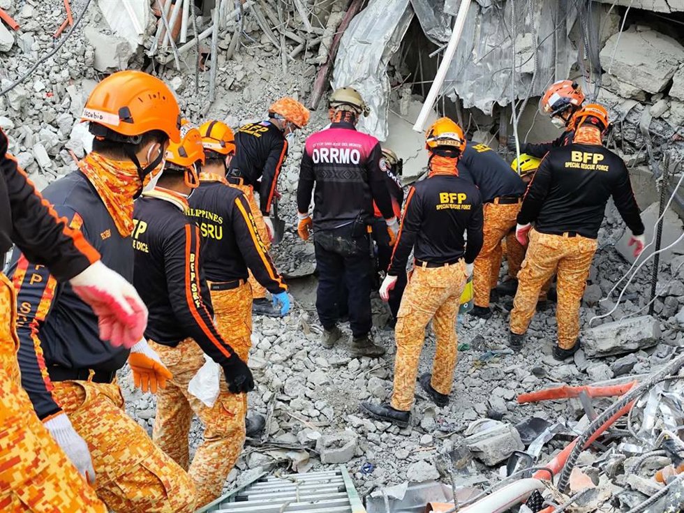 Equipos de rescate filipinos trabajan para extraer los cuerpos de las víctimas de un derrumbe de un edificio de nueve plantas en construcción