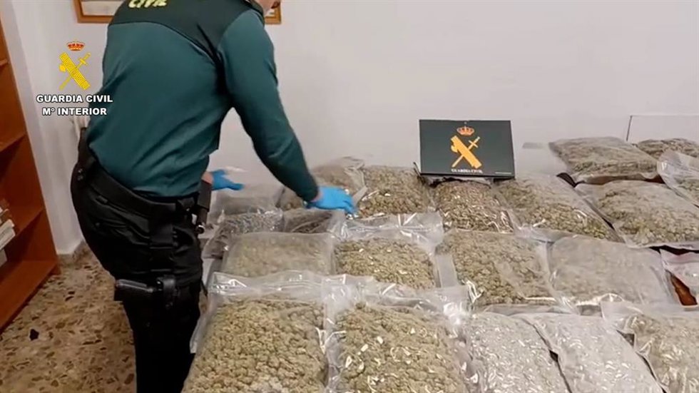 Un guardia civil con la droga incautada.